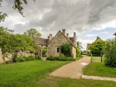 Outside view of buildings at Kelmscott Manor looking down drive towards front gate