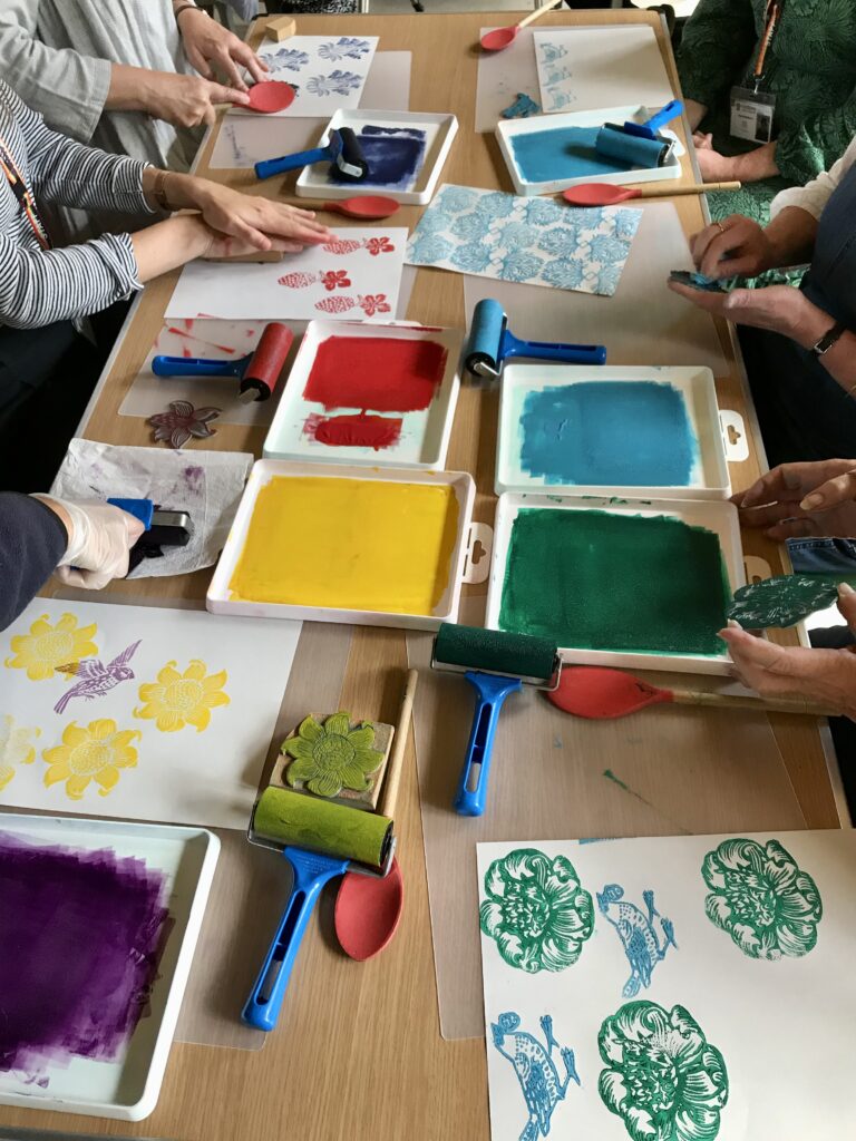 A group of people printing patterns on paper.