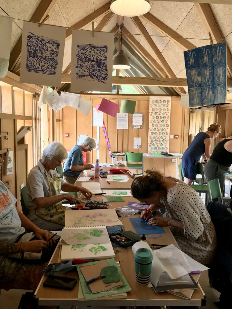 A group of adults take part in a printmaking workshop