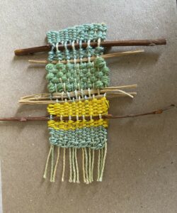 green and yellow weaving sample on sticks
